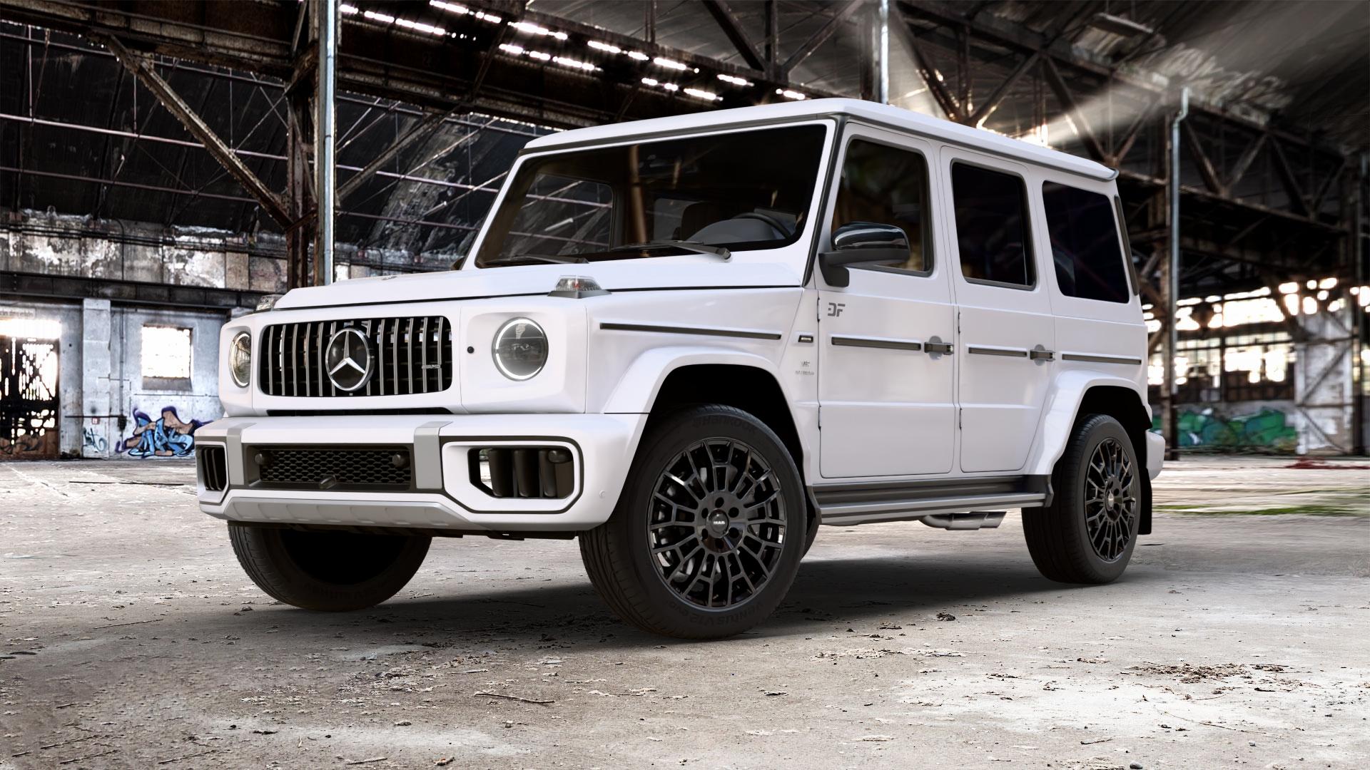 MAK Nomad Gloss Black Felge mit Reifen schwarz in 20Zoll Alufelge auf weissem Mercedes G-Klasse Typ W465 3,0l G 450d 270kW Mild-Hybrid (367 PS) 500 330kW (449 0,0l 580 EQ 223kW (303 4,0l 63 AMG 430kW (585 ⬇️ mit 15mm Tieferlegung ⬇️ Old Industrial Hall_max_5300mm_2024 Frontansicht_1